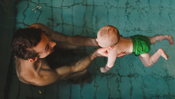 A father on paternity leave with his child in a swimming pool