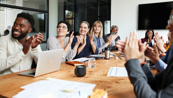 Happy employees applauding in a meeting room