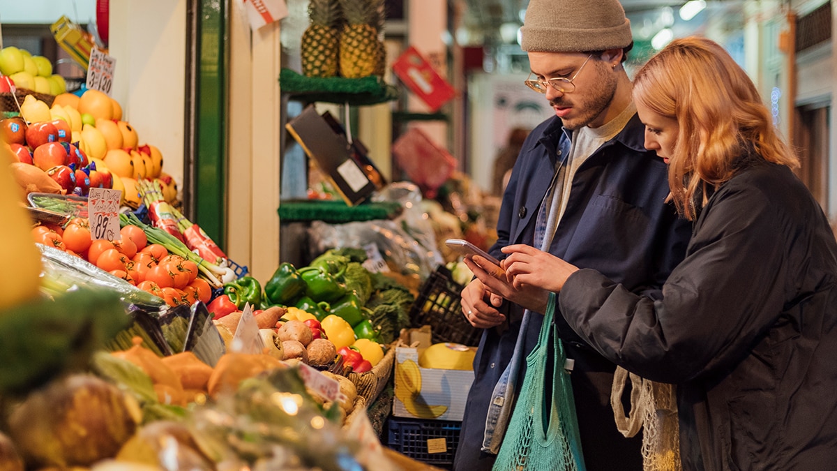 Two people buying food at a market