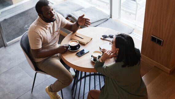 Two colleagues discussing fertility policy at work