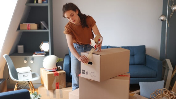 An employee packing up their belongings in their home in preparation for relocating for work
