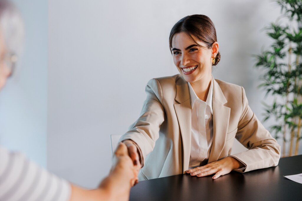 A woman shaking hands following successful salary negotiations