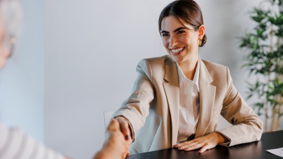 A woman shaking hands following successful salary negotiations