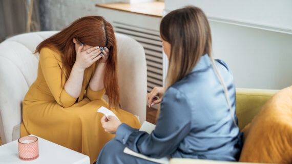 A manager comforting an employee struggling with stress at work