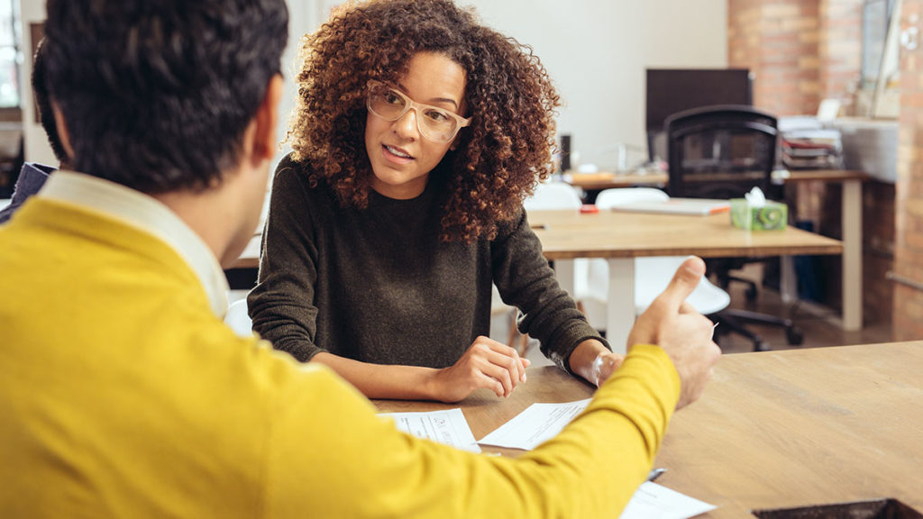 An image of a woman and a man having a meeting in an office.