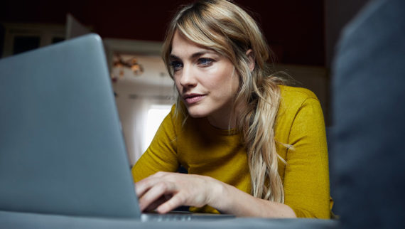 An image of a woman looking at her laptop screen.