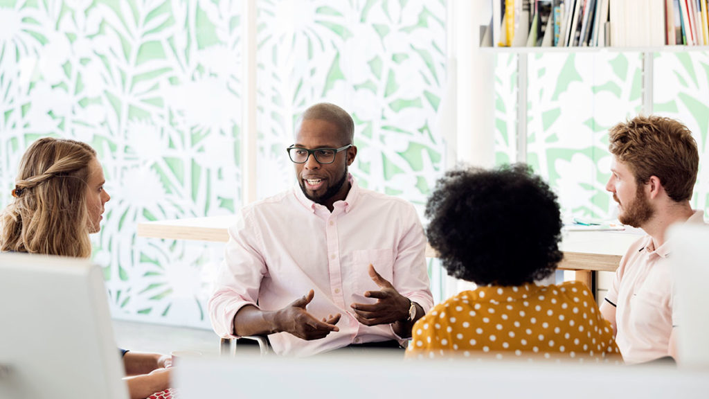 A manager having a meeting with his team