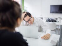 Two colleagues reviewing work on a laptop together
