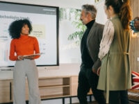 Business professionals collaboratively discussing recruiting trends in a modern office setting, with a focus on the developments of the market