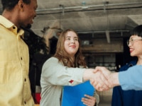 Workers welcoming a new colleague following a successful competency-based hiring process