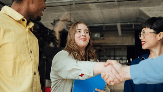 Workers welcoming a new colleague following a successful competency-based hiring process