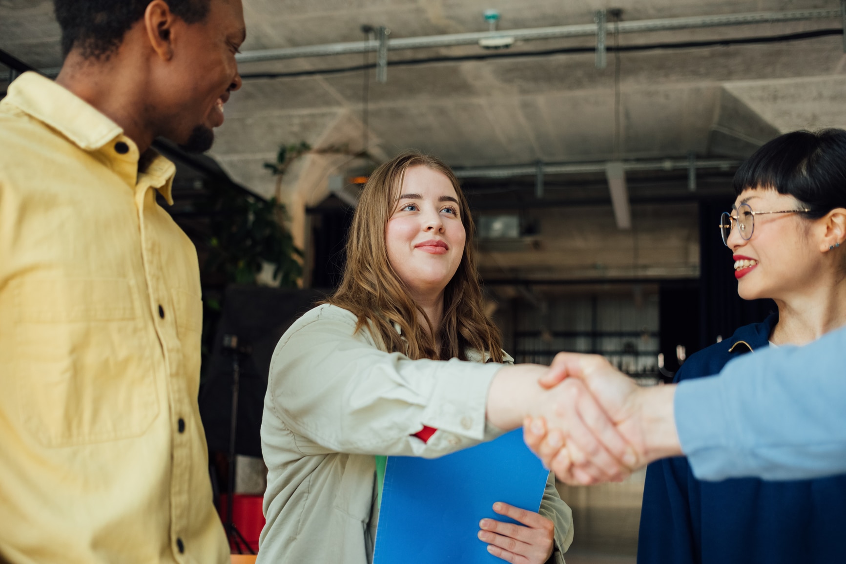 Workers welcoming a new colleague following a successful competency-based hiring process