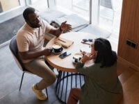 Two colleagues discussing fertility policy at work