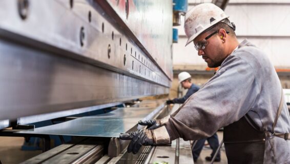 Man working in manufacturing with a sheet of metal
