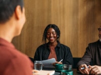 Employers interviewing job candidate in cafe