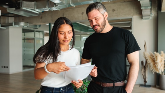 Two colleagues reviewing a document together in a modern office — illustrating hiring teams navigating the UK job market in 2026.