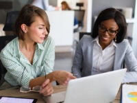 Two colleagues conducting the salary benchmarking process in an office environment