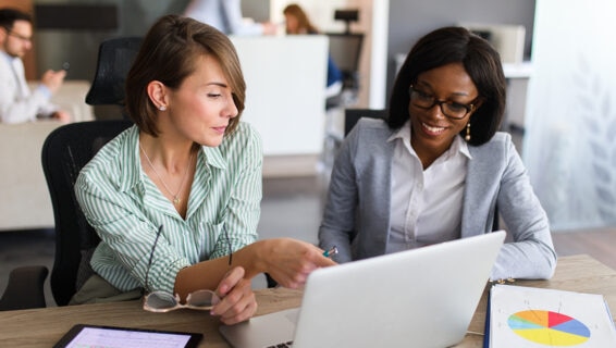 Two colleagues conducting the salary benchmarking process in an office environment