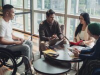 A diverse group of colleagues conducting a meeting round a table in an office setting