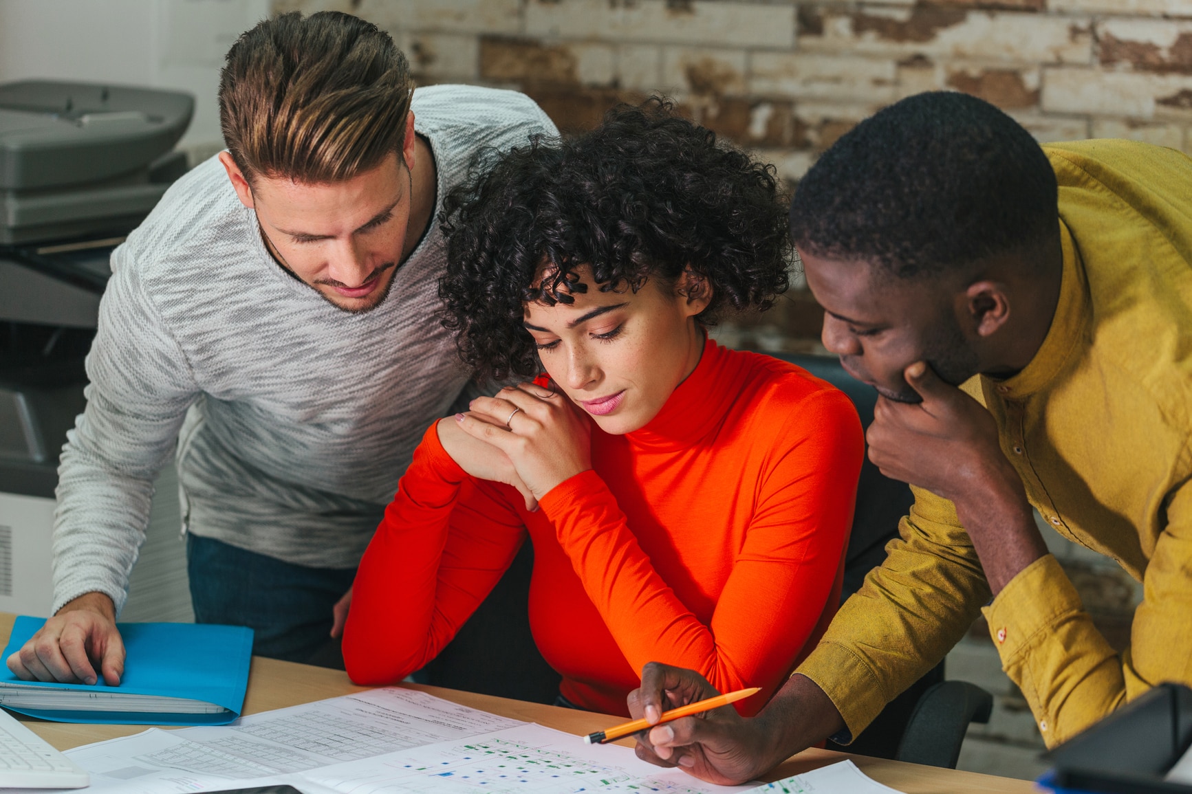 Group of young multiethnic men and woman coworking on new plant draft sitting at desk