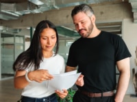 Two colleagues reviewing a document together in a modern office — illustrating hiring teams navigating the UK job market in 2026.