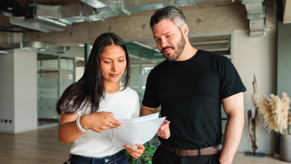 Two colleagues reviewing a document together in a modern office — illustrating hiring teams navigating the UK job market in 2026.