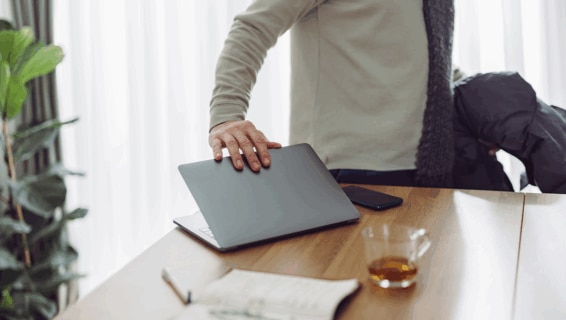 An employee shutting their laptop down as they prepare to go on Gardening Leave