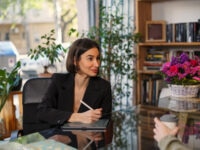 Elegant woman in black formal wear taking notes in a notebook