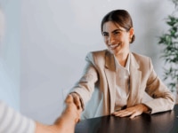 A woman shaking hands following successful salary negotiations