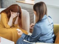 A manager comforting an employee struggling with stress at work