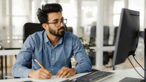 A busy male employee making notes on candidates during the screening process
