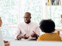 A manager having a meeting with his team